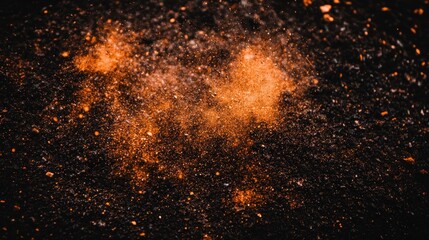 Orange dust explosion on dark ground, abstract background texture