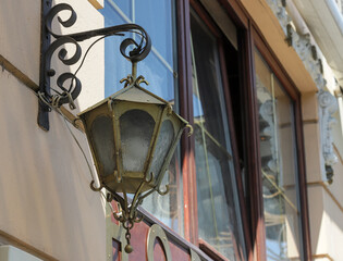 Decorative street lamp hanging on a historic building in Bucharest, Romania showcasing the city's...