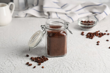 Jar of coffee powder with beans on white background