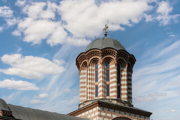 Historic church tower showcases intricate architecture under a clear blue sky in Romania during...