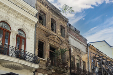 Naklejka premium Old architectural building in Bucharest showing neglect with trees growing from the rooftop on a bright day