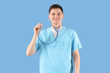 Male medical intern with stethoscope on blue background