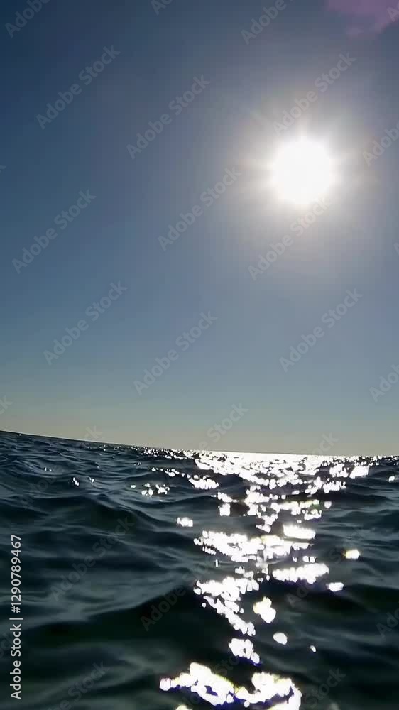 Poster sparkling ocean waves under bright sunlight in motion sequence