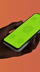Black African-American middle aged male using smartphone with a blank green screen. Mobile app video mockup. Vertical phone orientation
