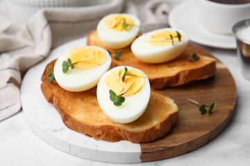 Sandwiches with hard boiled eggs on white marble table, closeup