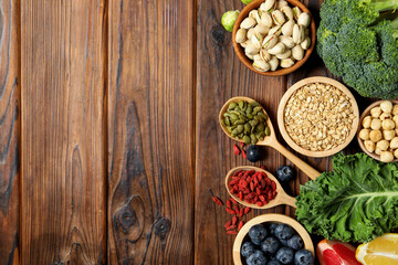 Different superfood products on wooden table, flat lay. Space for text