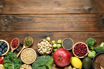 Different superfood products on wooden table, flat lay. Space for text