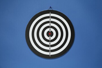 One dart board hanging on blue wall