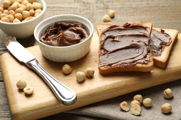 Sandwiches with chocolate butter, hazelnuts and knife on table, closeup