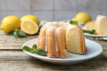 Delicious lemon cake with glaze and mint on wooden table, closeup