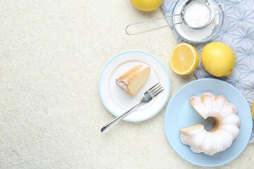 Delicious lemon cake with powdered sugar and citrus fruits on light textured table, flat lay. Space for text