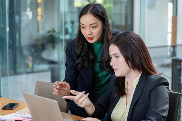 Two business professionals collaborating on financial strategy and analysis in a modern office setting.
