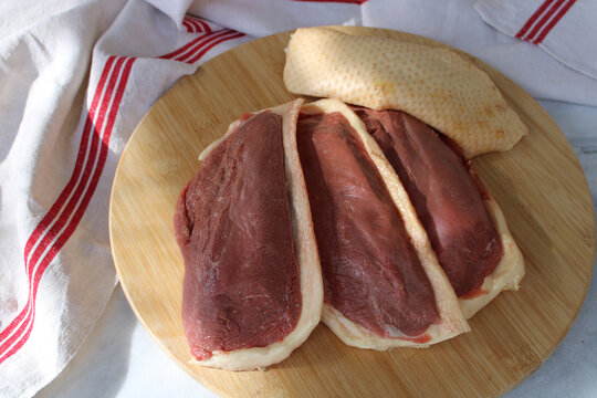 Magret de canard cru sur une planche en bois