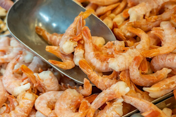 Frozen langoustines on counter in freezer chest in supermarket close-up.