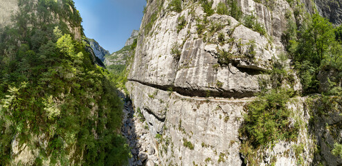 panorama Drone shot of the galleries in the Mrtvica River canyon,  a passage through a rocky mountain with a tunnel like opening, lacking one wall
