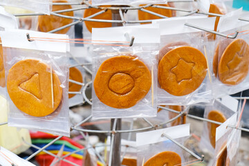 Korean Dalgona Candy, round sugar cookie with shape inside, street food
