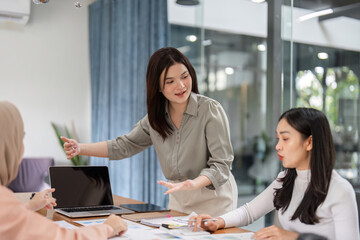 Professional women in a meeting, analyzing budget and financial strategies together.