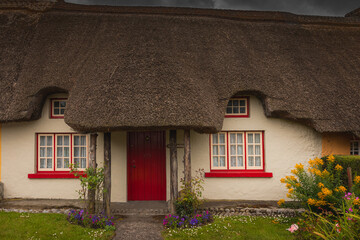 An Enchanting Thatched Cottage Nestled Amidst a Vibrant Display of Bright Flowers. Adare, Ireland 07.21.2019. Thatched cottage in the picturesque Village of Adare, Co. Limerick 2019 Ireland, Europe