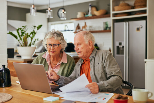 Focused elder couple managing home finances
