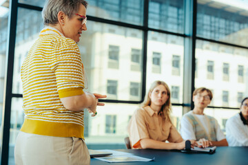 Teacher leading a small class discussion with attentive students in a modern classroom environment, preparing for graduate studies