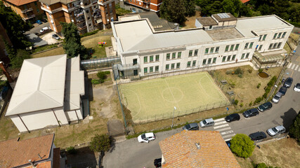 Aerial view of a closed white school with a playground.