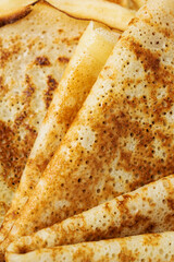 Close-up of a fried pancakes folded into triangles for Maslenitsa or Shrovetide. Traditional Russian holiday dish for a feast. Macro photography