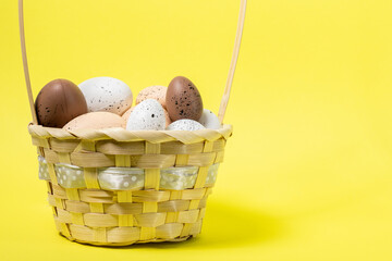 easter basket with speckled eggs on a yellow background, symbolizing spring and holiday traditions
