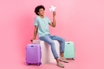 Full size photo of nice young guy sit cube hold paper plane travel bags dressed stylish blue outfit...