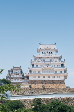 A direct front-facing view of Himeji Castle's main keep, showcasing its multi-tiered white walls, stone base, and intricate traditional Japanese architectural elements.