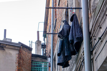 laundry hung out to dry on an outdoor dryer on an old tenement house. laundry hung out of a...