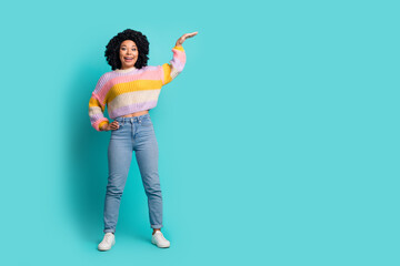 Stylish Young Woman in Colorful Sweater Against Teal Background Showing Gestures with Enthusiastic...