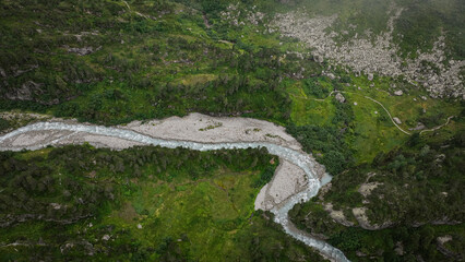 Lush valley near Gadmen Switzerland with winding river and rocky hillside