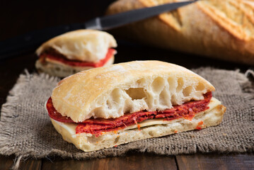 Hearty homemade chorizo and cheese sandwich on rustic table