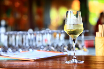 a glass of white wine served in a restaurant, abstract background of a summer restaurant