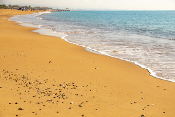 Small pebbles on the sand. Empty beach on the Mediterranean Sea in low season on a sunny day. Sorgun, Antalya province, Turkey. November
