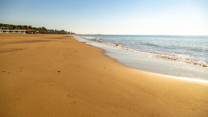 Empty wide sandy beach on the Mediterranean Sea in low season on a sunny day. Sorgun, Manavgat, Antalya province, Turkey. December