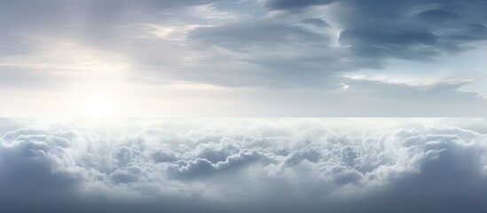 Obraz premium Serene panoramic view of gray clouds under a soft blue sky with hints of sunlight illuminating the horizon in a tranquil morning scene