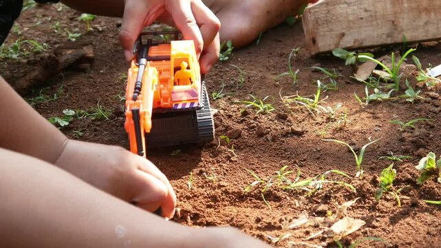 boy playing in the dirt with toy excavator