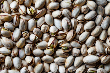 Tasty unpeeled pistachios , top view, closeup. Pistachios texture and background. Pile pistachio kernels nuts with shells