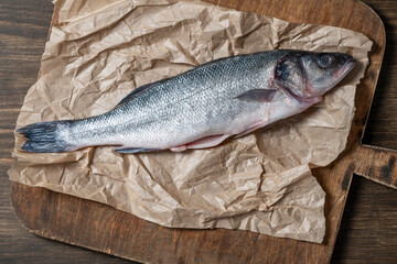 Fresh sea bass fish for cooking on a cutting board, closeup, top view. Raw peeled seabass prepared for cooking