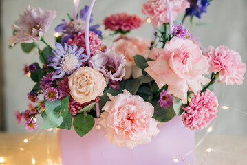 Beautiful pink flowers composition in the box close-up view. Festive decoration and background