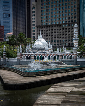 Kuala Lumpur, Malaysia - 27 April 2023: View of masjid jamek sultan abdul samad with modern skyscrapers and scenic river, Kuala Lumpur, Malaysia.