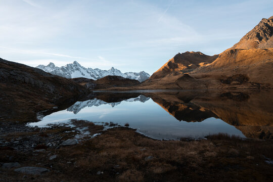 View of tranquil Lacs de Fenetre with majestic mountains and autumn reflection, La Fouly, Switzerland.
