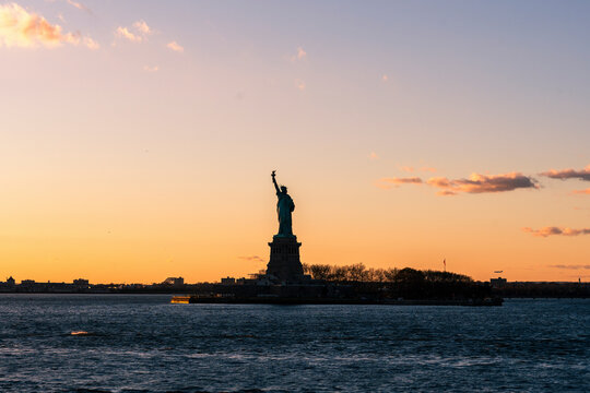 View of the majestic Statue of Liberty at sunset with a scenic skyline, New York, United States of America.