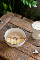 Oatmeal with banana and seeds. wooden background, side view