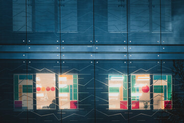 View of illuminated modern buildings with colorful lights and reflections at night, Vilnius, Lithuania.