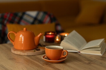 Cozy autumn tea setting with candles and open book