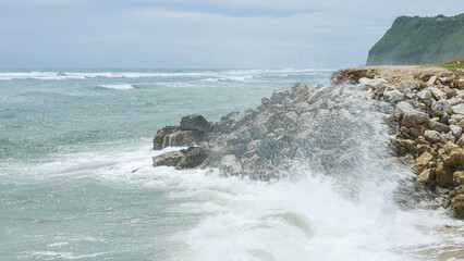 BALI, INDONESIA - JANUARY 22, 2018: Scenic Balinese rocky shore, green cliff and Indian Ocean waves, medium shot