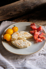 cheese flatbread, yellow cherry tomatoes and trout pieces on a plate with 