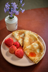 Crepes with strawberries. Foreground, wooden background